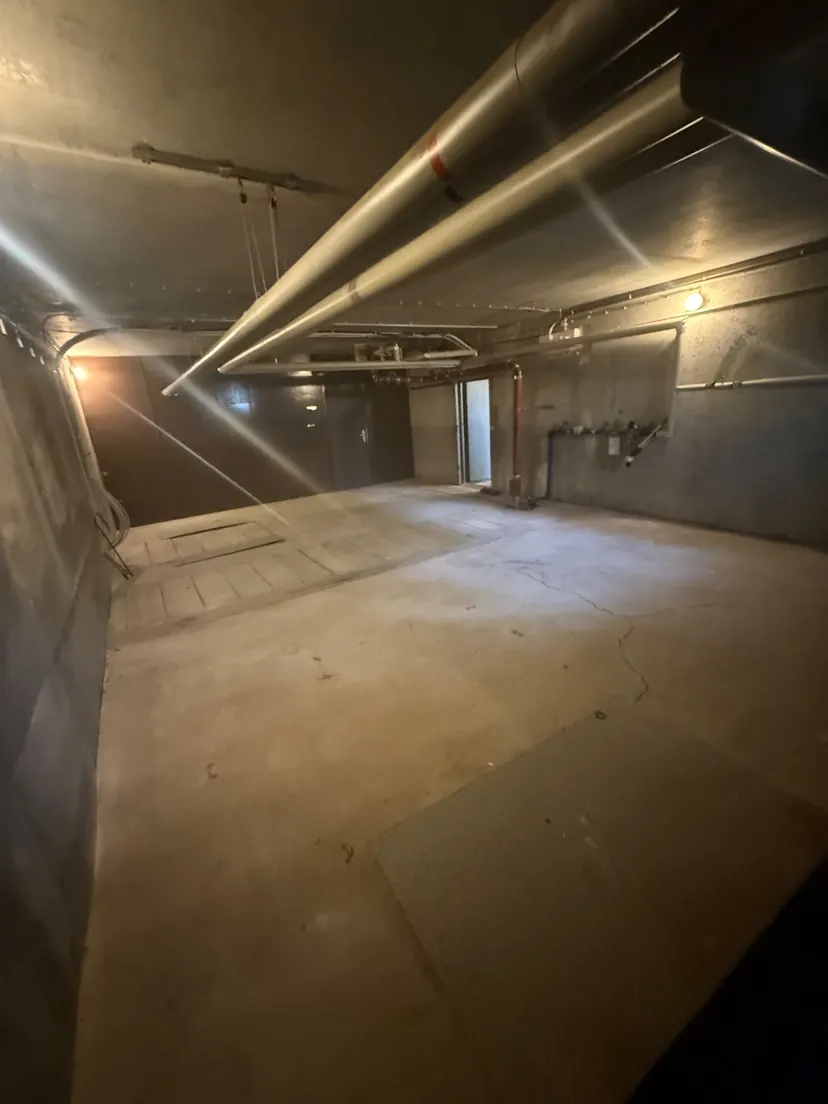 Großer geräumter Kellerraum mit Rohrleitungen unter der Decke