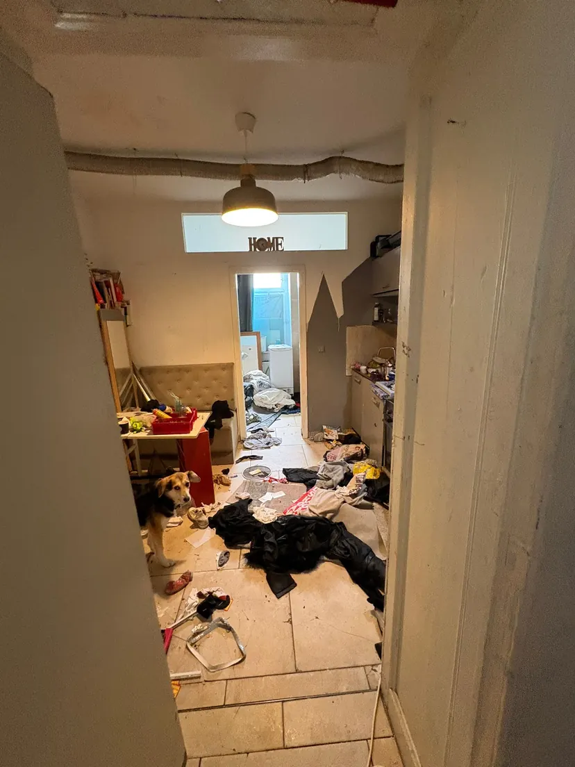 Flur einer Wohnung, der mit Tüten, Kartons und Gegenständen zugestellt ist